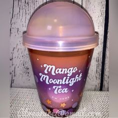 a purple cup with the words mango moonlight tea on it's lid sitting on a table