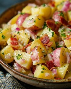 a bowl filled with potatoes and bacon on top of a table