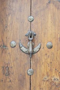 an old wooden door with metal handles and knobs