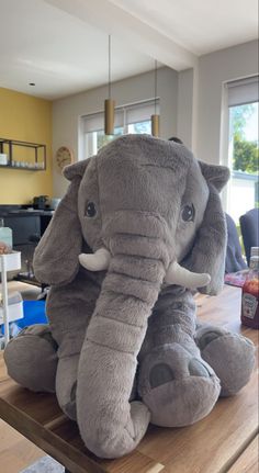 an elephant stuffed animal sitting on top of a wooden table