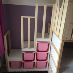 there is a bunk bed with pink bins on it