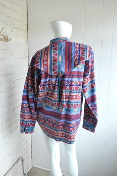 "A fantastic Aztec-style cotton blouse by Adobe Rose. The shirt features unique button / flap details on the front and back, with an open pleat in the back. Made in Hong Kong in 1993. CONDITION: Fantastic, with minor fading and a run or two in the fabric. Near new condition. MEASUREMENTS Bust: 44\" Length: 31\" Have a question? Please ask me anything." Bohemian Long Sleeve Tops With Pockets, Oversized Cotton Bohemian Blouse, Bohemian Cotton Button-up Shirt, Festival Cotton Tops With Buttons, Cotton Festival Tops With Buttons, Oversized Bohemian Tops With Pockets, Bohemian Oversized Tops With Pockets, Bohemian Long Sleeve Tops With Button Closure, Bohemian Long Sleeve Top With Button Closure