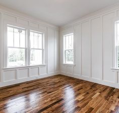 an empty room with white paneling and wood floors is pictured in this image from the inside