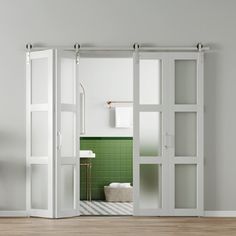 an open door leading to a bathroom with green tile