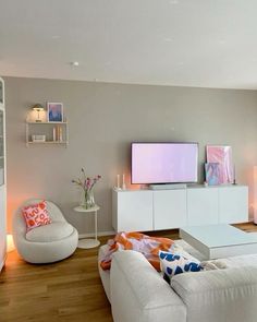 a living room filled with furniture and a flat screen tv on top of a wall