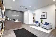 an office lobby with two chairs and a reception desk