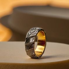 a gold wedding ring sitting on top of a table