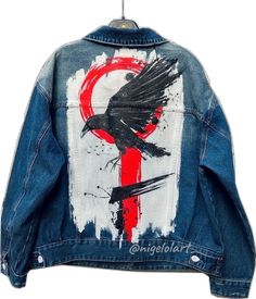 a jean jacket with a bird painted on it