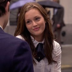 a young woman wearing a black tie standing next to a man in a white shirt