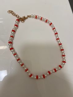 A necklace with red clay beads and (fake) pearls in between Red Pearl Beaded Necklace With Round Beads, Red Pearl Beaded Chain Jewelry, Red Pearl Jewelry With Colorful Beads, Red Pearl Beaded Necklaces With Pearl Chain, Red And White Beaded Necklace, Elegant Red Beaded Pearl Necklace, Red Pearl Necklace With Pearl Chain, Red Pearl Necklace With Round Beads, Red And White Pearl Necklace