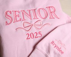 "This cute and comfy sweatshirt is a great gift choic for any high school or college senior or grad. Available in various sizes, two styles (crewneck and hoodie) and multiple colors. Option to customize the sleeve with a name, school, initials, etc.  Perfect gift for birthday, holidays and graduation. Grad Gift, New Grad Gift, Graduation Sweatshirt, College Graduation, Graduation Gift, High School Graduation, Christmas gift for Grad, Senior Night \"SENIOR\" will be embroidered in the preppy arch Diy Senior Sweatshirt, Senior Backpacks Funny, Senior Year Sweatshirts, Senior Hoodies Diy, Senior Hoodies Design Ideas 2025, Senior Diy Projects, Senior Crewneck Ideas, Senior Jersey Ideas, Senior Year Outfits High Schools