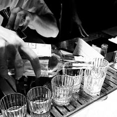 a person is pouring water into glasses on a tray