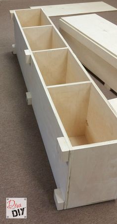 two wooden drawers sitting on top of each other in the middle of an area with carpeted flooring