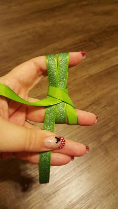 a woman's hand holding a green ribbon