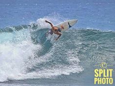 a man riding a wave on top of a white surfboard in the middle of the ocean