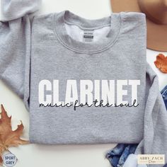 Show your marching band spirit with this clarinet fuels the soul crewneck sweatshirt. We print on warm and cozy Gildan brand sweatshirts. More band and orchestra instrument shirts available at my homepage https://www.etsy.com/shop/AbbyZachDesigns ----HOW OUR SHIRTS ARE MADE ----  * We use the process of DTG, which stands for direct to garment printing. We partner with a professional printer who applies ink directly into the shirt. (We do not use vinyl.) This gives you better quality and will not Fall Band Logo Crew Neck Sweatshirt, Fall Crew Neck Sweatshirt With Band Logo, Fall Band Merch Sweatshirt With Band Logo, Music-themed Long Sleeve Sweatshirt For Fall, Clarinet Shirts, Band Sweater, Music For The Soul, Brand Sweatshirts, Clarinet Music