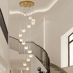 an elegant staircase with chandelier and glass balls hanging from the handrails