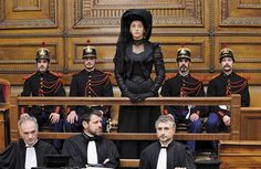 a group of men and women sitting in front of a judge's bench wearing black robes