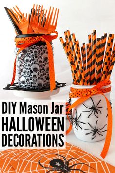 two mason jars decorated with halloween decorations and spider webs on the top, one is orange and black