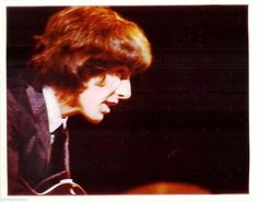 an old photo of a young man playing the guitar