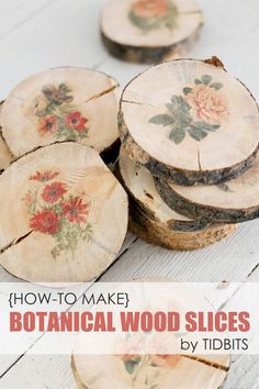 wood slices with flowers painted on them sitting on a white wooden table next to each other