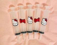 five plastic tubes with hello kitty designs on the side and one has a red bow