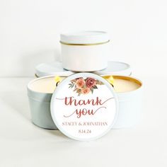 two small tins filled with wedding favors and the words thank you written on them