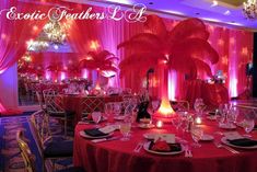 a banquet room set up for a party with pink and purple lighting on the walls