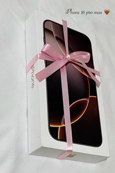 an open box with a pink ribbon tied around the inside of it on a white surface