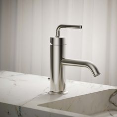 a bathroom sink with a faucet and marble counter top