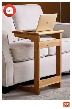 a laptop computer sitting on top of a wooden table in front of a white couch