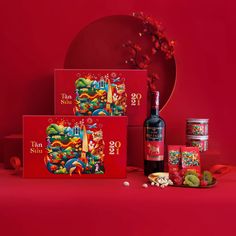 the chinese new year's gift set includes two bottles of wine, candy and snacks