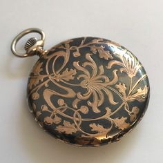 RARE ANTIQUE Silver case with Niello & Rose Gold Patterning Pocket Watch c.1915. Silver cased pocket watch with Niello & rose gold floral patterning to rear of case. Inner cover having the inscription '11 November 1890 - 11 November 1915'. Rare dial having black arabic numerals and minute index set in guilded chapter ring. Guilded subsidiary seconds dial at 6 o'clock and copper and silver vertical stripes to centre of dial. Dial signed 'Tavannes Watch Co'. Blue steel hands. Mechanical Swiss Lever movement. Bow wound & hand set. Case hallmarked 0.900 continental silver. Please note this a most rare watch. Watch dimensions - 47mm diameter. Height inc. bow 61mm. This watch is sold with a 12 month guarantee from Fine Times MBHI certificated watchmakers, established 1947. All watches will be se Vintage Engraved Bronze Pocket Watch, Vintage Engraved Watch Accessories As Gift, Antique Round Pocket Watch With Antique Finish, Formal Victorian Style Pocket Watch, Victorian Engraved Watches For Formal Occasions, Victorian Pocket Watch For Formal Occasions, Antique Silver Watch Accessories As Gift, Antique Silver Watch Accessories For Gift, Victorian Pocket Watch With Round Dial For Formal Occasions