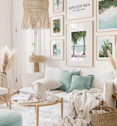 a living room filled with white furniture and pictures on the wall above it's coffee table