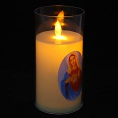 a lit candle with an image of the virgin mary on it