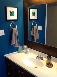 a bathroom with blue walls and white counter tops