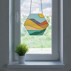 a potted plant sitting on top of a window sill in front of a stained glass window