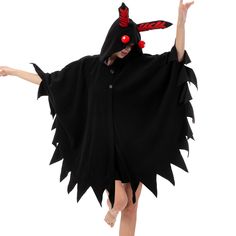 a woman in a black cape with red eyes and horns on her head is dancing