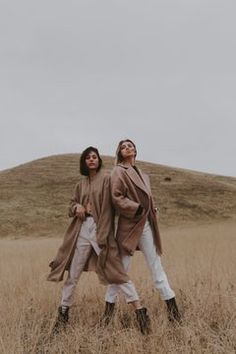 two people standing in the middle of a field