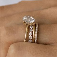 a woman's hand with two gold rings and a diamond ring on her finger