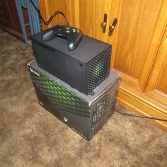 a video game system sitting on top of a box in front of a wooden door