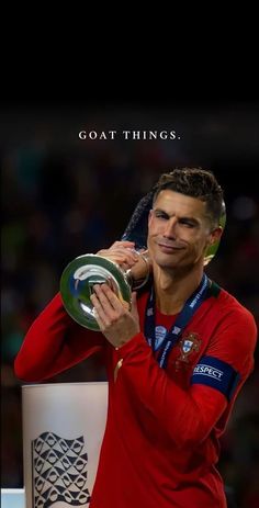 a man holding a trophy in front of his face with the caption goat things