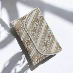 Presenting our stunning handcrafted off white envelope clutch. This piece has been painstakingly handcrafted by our artisans using traditional Pakistani and Indian techniques, as well as fine thread work, glass crystal embellishments, and beadwork. This clutch is the perfect accessory for weddings, parties, or any special occasion. Our clutch measures 10 inches and features a flap closure that securely fastens with a snap. The spacious interior can fit your essentials, and the detachable strap allows for versatile styling. Because each piece is unique, there could be very tiny differences in the design and color. Product Details: *Handmade with traditional Pakistani and Indian techniques *Intricate thread work, Crystal and beads  embellishments *Spacious interior and detachable strap *Meas Elegant Beige Evening Bag With Handwork, White Embellished Clutch For Party, Traditional Cream Rectangular Evening Bag, Handwork Beige Elegant Evening Bag, White Rectangular Evening Bag For Festive Occasions, Festive White Clutch For Party, White Festive Clutch For Party, Festive White Rectangular Evening Bag, Handmade Beige Evening Bag For Wedding