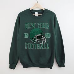 Perfect sweatshirt for any Jets football fans this season! Ideal for any situation, a unisex heavy blend crewneck sweatshirt is pure comfort. These garments are made from polyester and cotton. This combination helps designs come out looking fresh and beautiful. The collar is ribbed knit, so it retains its shape even after washing. There are no itchy side seams on these sweaters.  .: 50% cotton, 50% polyester .: Medium-heavy fabric (8.0 oz/yd² (271.25 g/m .: Loose fit .: Sewn-in label .: Runs true to size CARE INSTRUCTIONS: -Please wash all clothing items INSIDE OUT to preserve the design. -Please wash all clothing items on cold, and dry on Medium- low heat. -DO NOT IRON. -DO NOT TIE DYE. **Please check our color and size charts before you place your order. If you have any questions please Crew Sweatshirt For Sports Events In Fall, Fall Crew Sweatshirt For Sports Events, Sports Season Crew Neck Sweatshirt With Screen Print, Football Season Graphic Print Fan Gear Sweatshirt, Football Season Fan Gear Sweatshirt With Graphic Print, Fall Team Logo Sweatshirt Fan Merchandise, Varsity Sweatshirt For Football Season Streetwear, Fall Sports Fan Sweatshirt With Crew Neck, Crew Sweatshirt With Screen Print For Sports Season