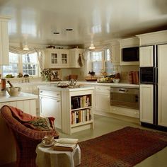 a kitchen filled with lots of white cabinets and counter top space next to a dining room table