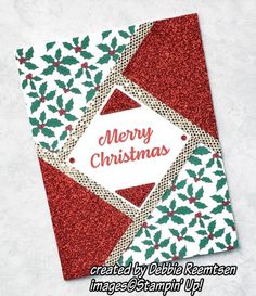 a merry christmas card with holly leaves and red glitter on the bottom, in front of a white background