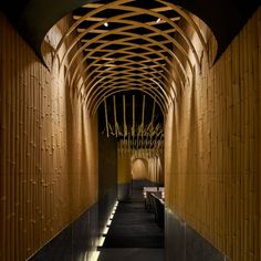 the inside of a restaurant with bamboo walls and ceilinging, along with tables and benches