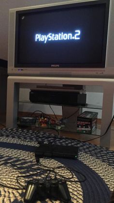 a flat screen tv sitting on top of a wooden table next to a video game controller