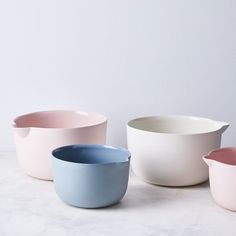 three different colored bowls sitting next to each other on a white counter top with one bowl in the middle