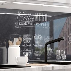 a black and white coffee menu is on the wall behind a kitchen faucet